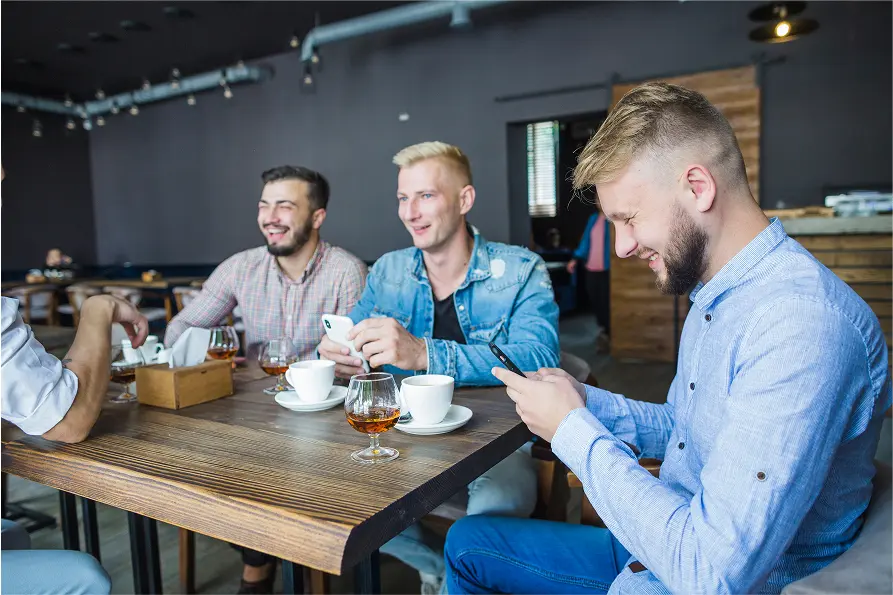 friends sitting restaurant using mobile phone